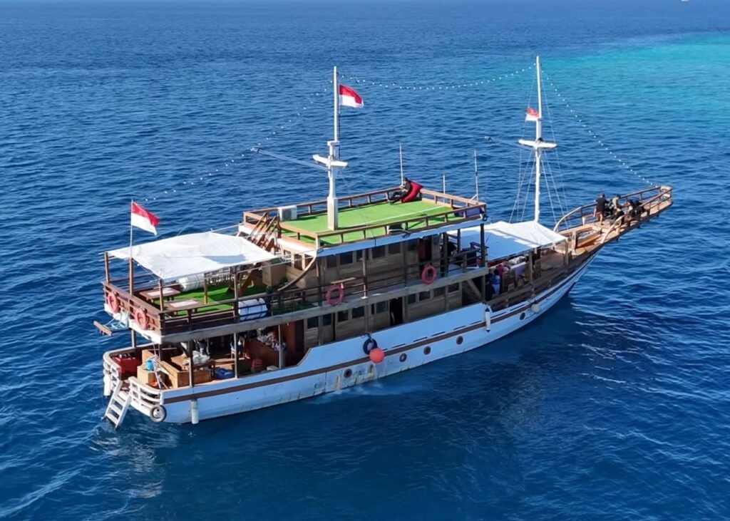 Foto udara kapal pinisi Sahabat Pinisi berbendera merah putih di laut Makassar