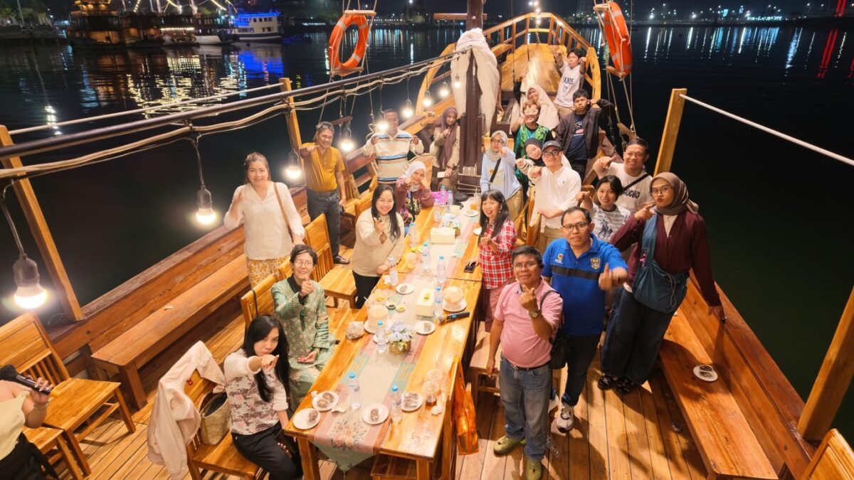 Tamu makan malam di dek kapal pinisi berhias lampu saat Moonlight Sailing Makassar