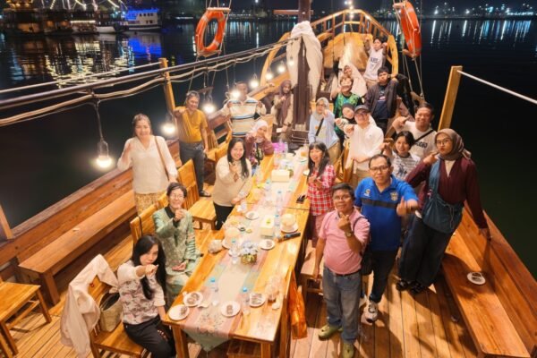 Tamu makan malam di dek kapal pinisi berhias lampu saat Moonlight Sailing Makassar