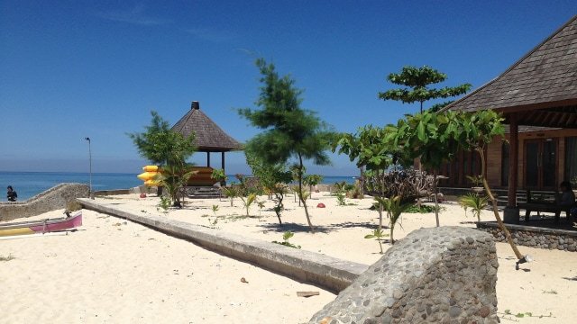 Pantai berpasir putih dengan gazebo dan pohon di Pulau Samalona Makassar